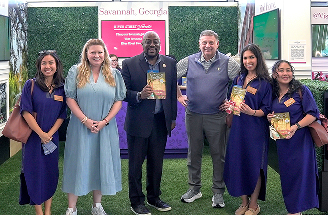 Visit Savannah is bringing the sights, sounds, flavors, and hospitality of Savannah directly to travelers at Chicago’s O’Hare International Airport through a four-week, multi-sensory brand activation in Terminal 3, which runs through May 24. Shown here with Savannah Brand Ambassadors, wearing navy Emily McCarthy dresses, are Angela Westerfield (second from left), Chief Marketing Officer, Visit Savannah; Savannah Mayor Van Johnson (center left); and Visit Savannah President & CEO, Joseph Marinelli (center right), President & CEO, Visit Savannah.